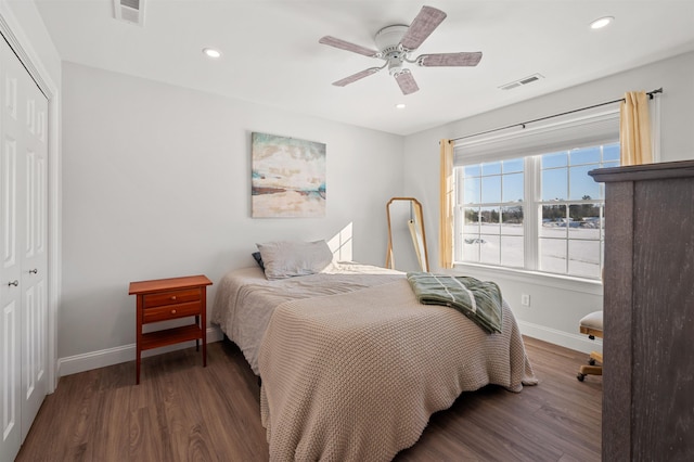 bedroom with visible vents, baseboards, a closet, and wood finished floors