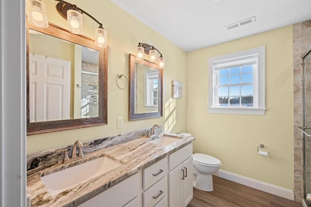 bathroom featuring visible vents, toilet, baseboards, and a sink