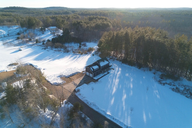 snowy aerial view featuring a forest view