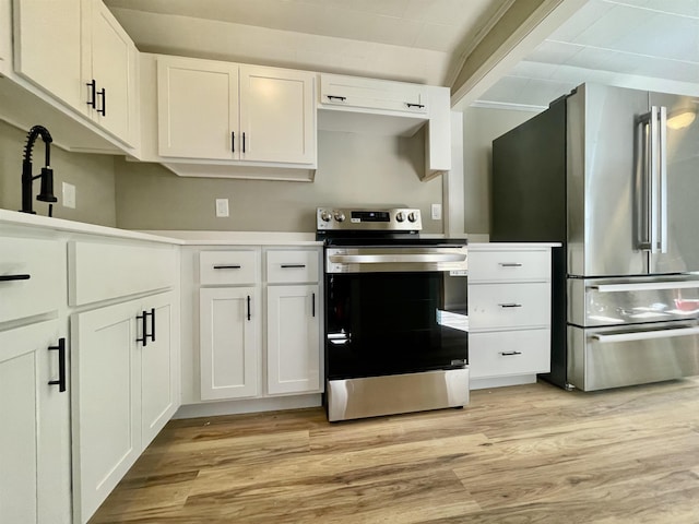 kitchen with white cabinetry, stainless steel appliances, light wood-type flooring, and light countertops