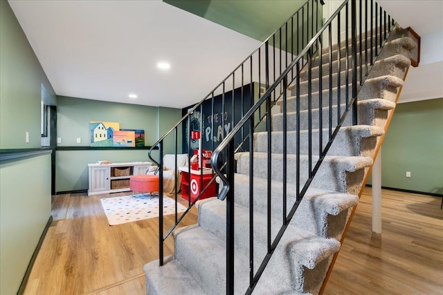 staircase with recessed lighting, wood finished floors, and baseboards