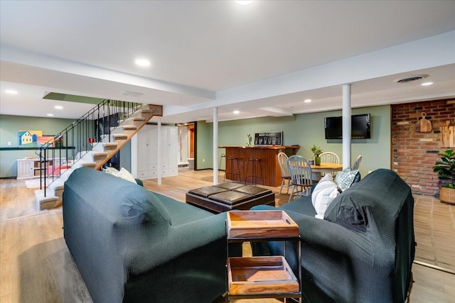 living room featuring recessed lighting, visible vents, wood finished floors, and stairs