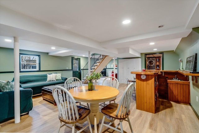 dining space with indoor wet bar, stairway, recessed lighting, and light wood-type flooring