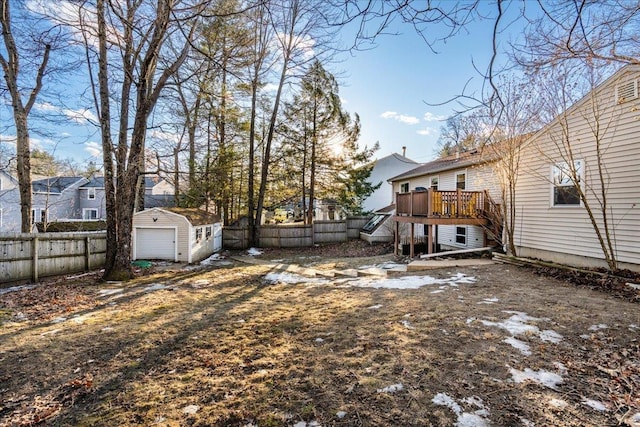 view of yard with an outbuilding, stairway, a wooden deck, a fenced backyard, and a garage