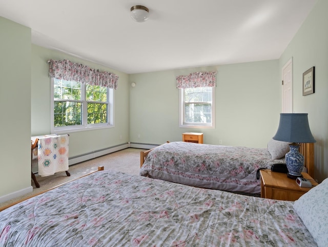 carpeted bedroom featuring baseboard heating, multiple windows, and baseboards