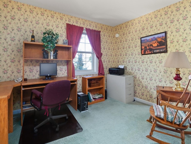 carpeted home office with wallpapered walls and baseboards