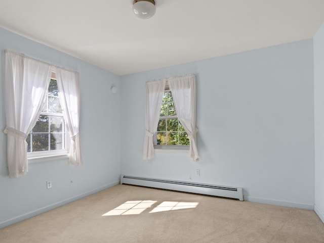 spare room featuring a wealth of natural light, baseboard heating, and carpet floors