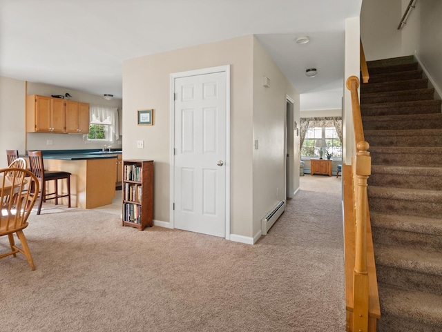 interior space with baseboard heating, a healthy amount of sunlight, and carpet