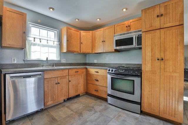 kitchen featuring a sink, stainless steel appliances, dark countertops, and recessed lighting