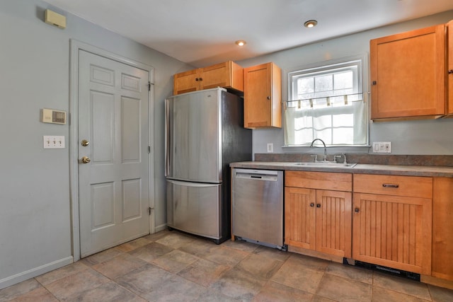 kitchen featuring dark countertops, baseboards, recessed lighting, stainless steel appliances, and a sink