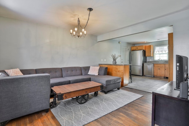 living area with a notable chandelier and light wood finished floors