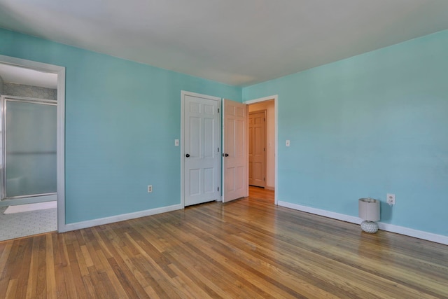 unfurnished bedroom featuring baseboards and hardwood / wood-style floors