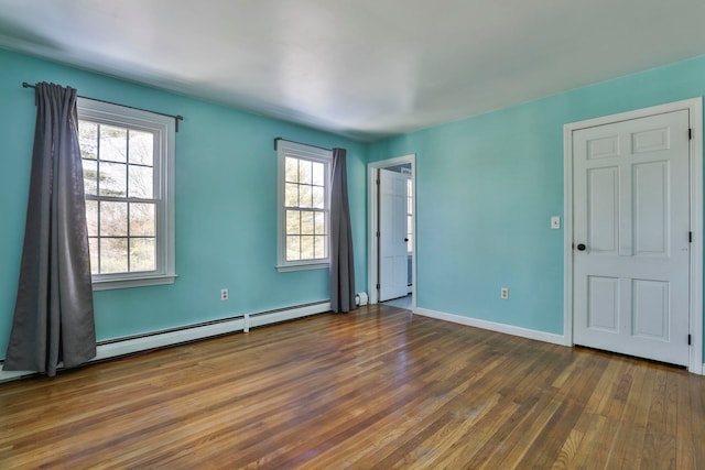 unfurnished room with wood-type flooring, baseboards, and baseboard heating