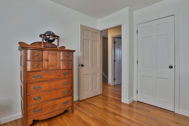 bedroom with light wood-type flooring and baseboards