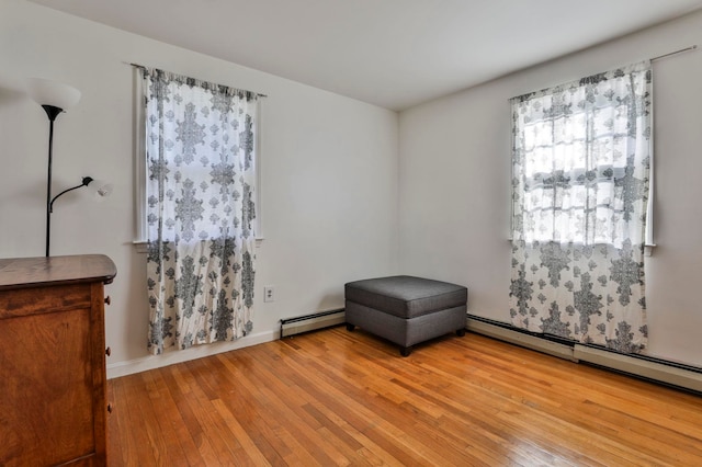 living area with hardwood / wood-style floors and a baseboard radiator