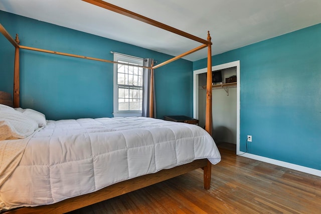 bedroom with a closet, baseboards, and wood finished floors