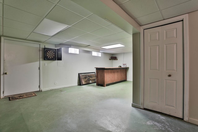 basement with baseboards and a paneled ceiling