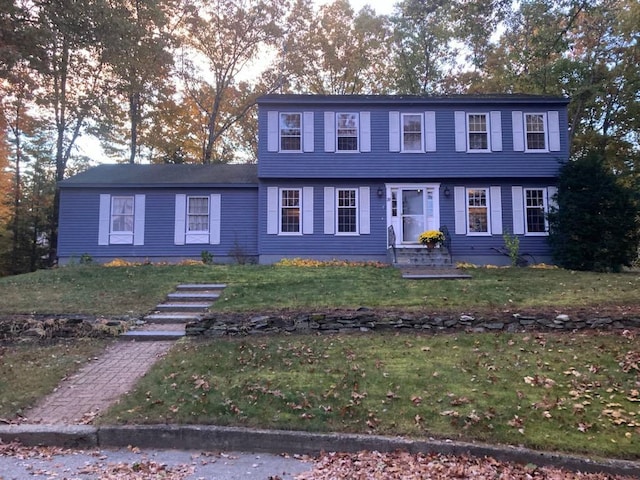 colonial house featuring a front lawn