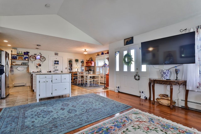 living room with light wood-style flooring, high vaulted ceiling, and a baseboard heating unit