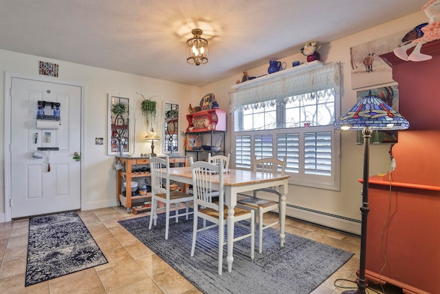 dining room with a chandelier, a baseboard heating unit, and baseboards