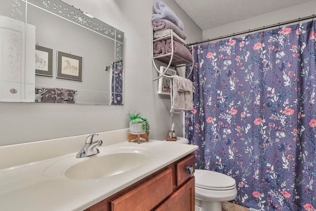 full bath featuring curtained shower, toilet, vanity, and a textured ceiling