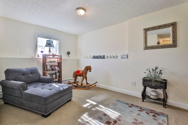 sitting room with baseboards, a textured ceiling, a baseboard heating unit, and carpet