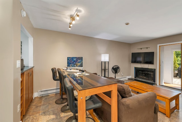 office area with a baseboard radiator, baseboards, a fireplace with raised hearth, and a baseboard heating unit