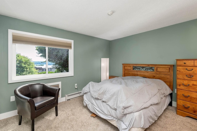 bedroom with light carpet, baseboard heating, and baseboards