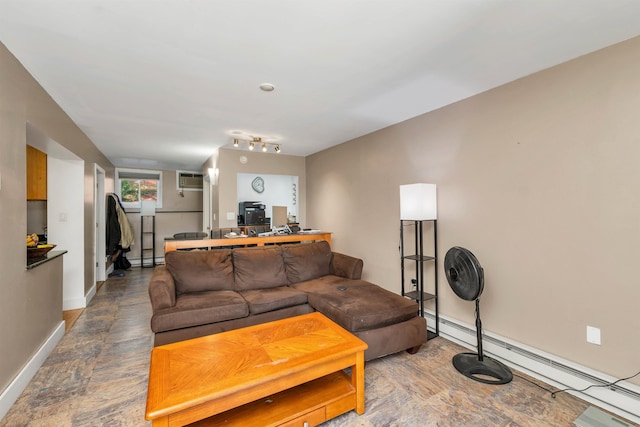 living area featuring a baseboard heating unit, an AC wall unit, and baseboards