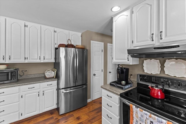 kitchen with recessed lighting, dark wood-style flooring, white cabinets, under cabinet range hood, and appliances with stainless steel finishes