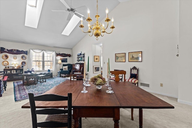 carpeted dining area featuring visible vents, high vaulted ceiling, ceiling fan with notable chandelier, a skylight, and baseboards