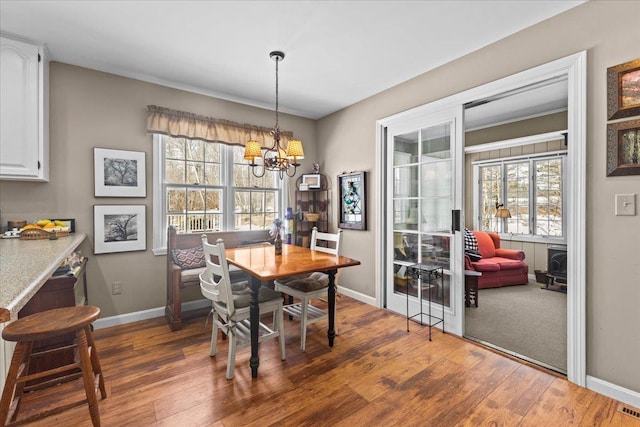 dining area with wood finished floors, baseboards, and a chandelier