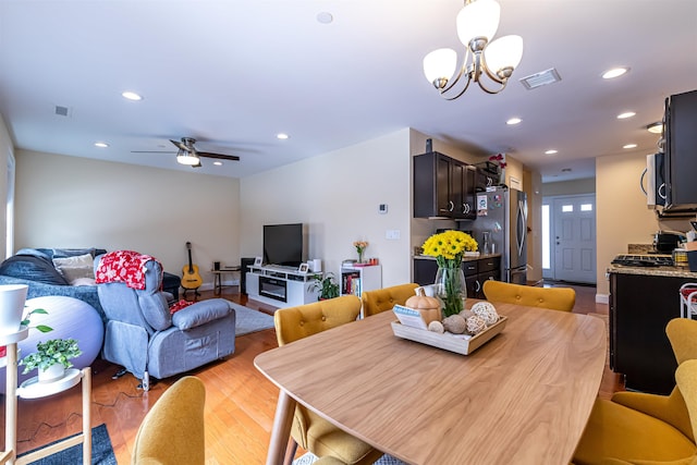 dining space with recessed lighting, visible vents, light wood-style flooring, and ceiling fan with notable chandelier