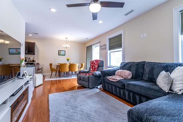 living area with visible vents, recessed lighting, and wood finished floors