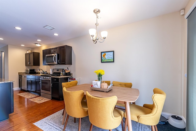 dining area featuring visible vents, baseboards, recessed lighting, wood finished floors, and a notable chandelier