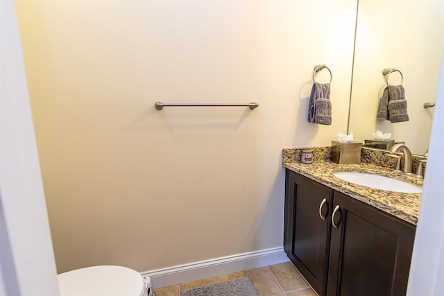 bathroom featuring tile patterned flooring, toilet, vanity, and baseboards