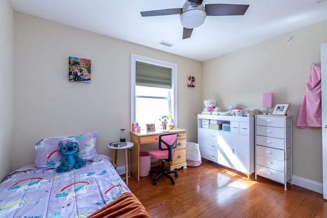 bedroom featuring visible vents, baseboards, a ceiling fan, and wood finished floors