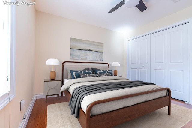 bedroom with ceiling fan, wood finished floors, a closet, and baseboards