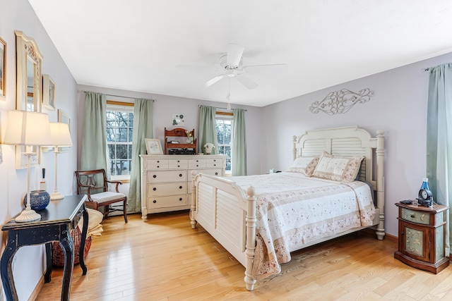 bedroom featuring light wood-type flooring, multiple windows, and ceiling fan