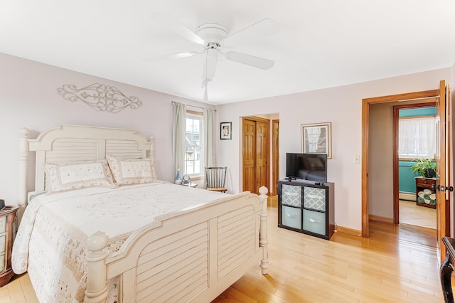 bedroom with baseboards, light wood-style floors, and a ceiling fan