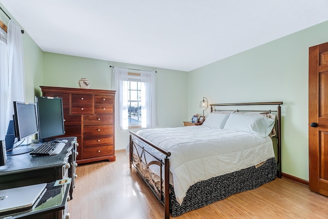 bedroom featuring baseboards and light wood finished floors