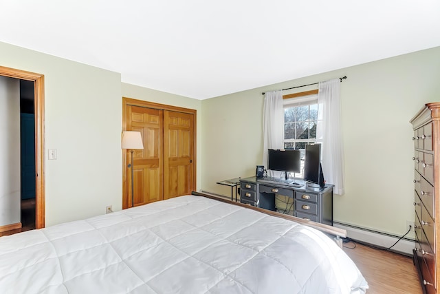 bedroom featuring wood finished floors and a baseboard radiator