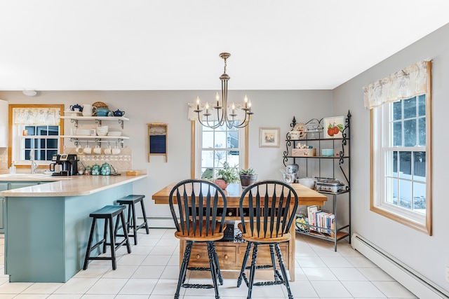 dining space featuring light tile patterned floors, a baseboard radiator, plenty of natural light, and an inviting chandelier