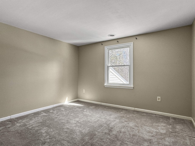 spare room featuring carpet flooring, baseboards, and visible vents