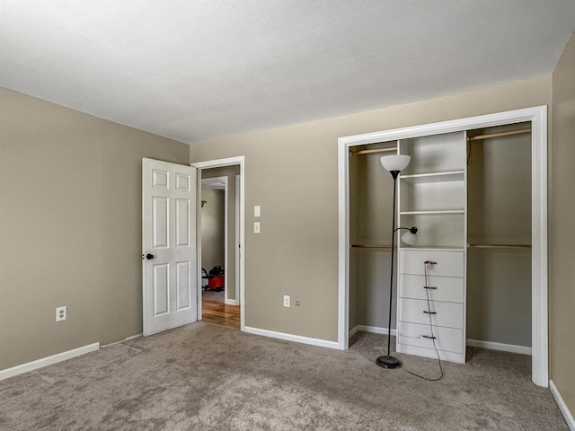 unfurnished bedroom with a closet, baseboards, and carpet