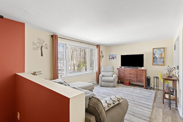 living area featuring baseboards and light wood-type flooring