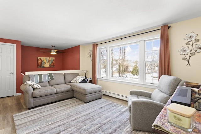 living room featuring a baseboard heating unit, a ceiling fan, and wood finished floors