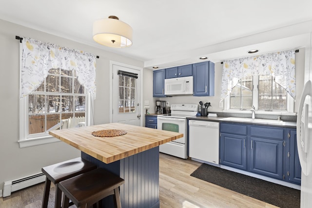 kitchen featuring white appliances, blue cabinets, a baseboard radiator, and a sink