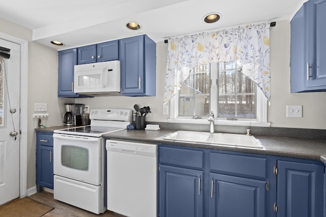 kitchen with white appliances, blue cabinetry, dark countertops, and a sink