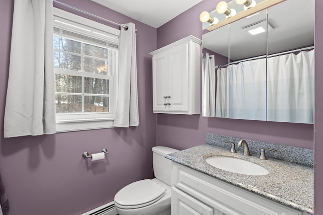 bathroom with vanity, toilet, and a baseboard heating unit